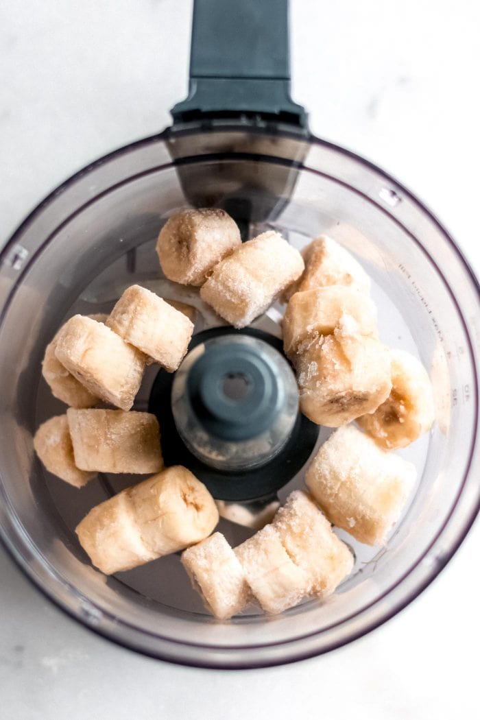 Food processor with frozen chopped banana in it.