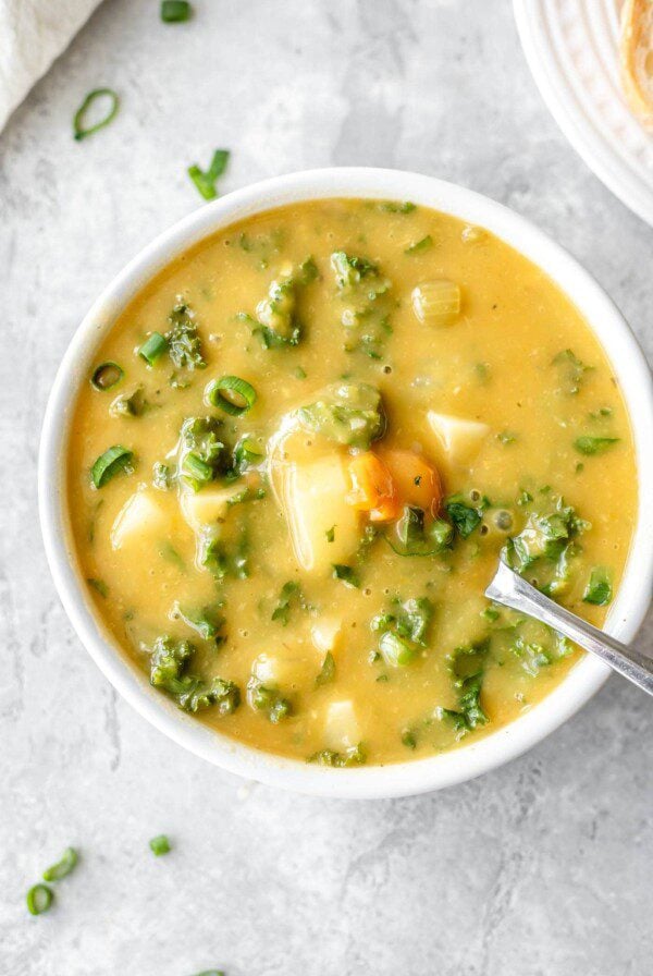 Overhead shot of a bowl of creamy potato soup with kale and carrot.