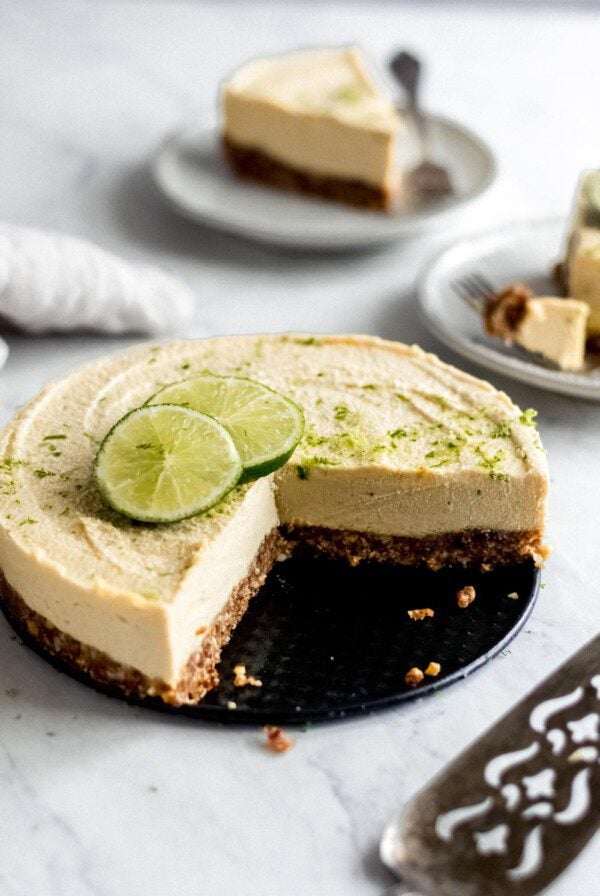 No-bake lime mango cheesecake on a tray with a serving knife.