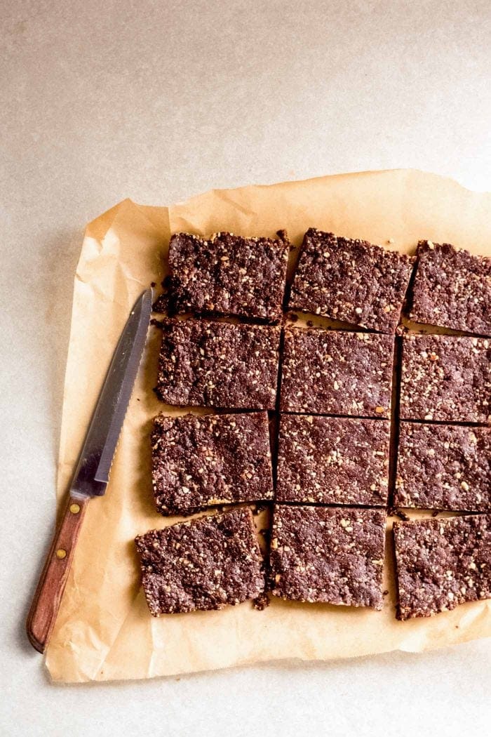 Chocolate energy bars cut into bars on a piece of parchment paper.