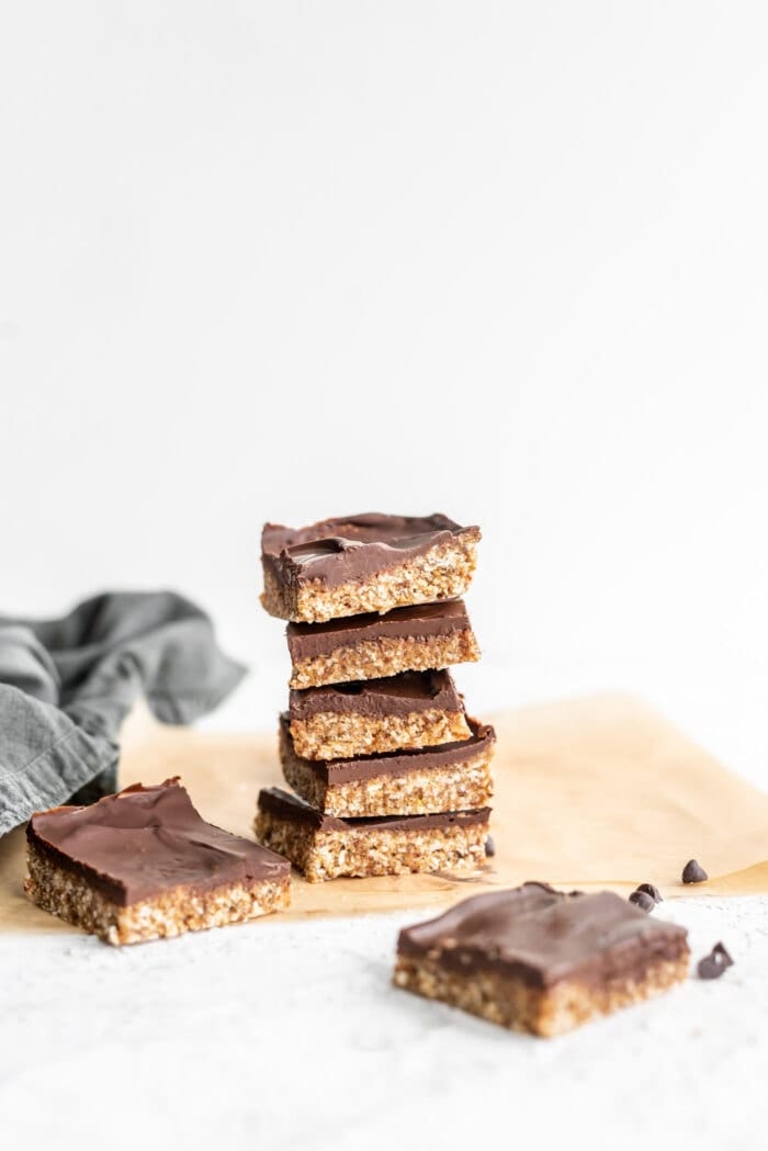 Stack of 5 chocolate coated coconut bars against a white background.