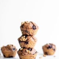 A stack of healthy vegan blueberry muffins sitting on a white surface.