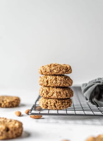 Stack of gluten-free vegan coconut almond date cookies sitting on a cooling rack.