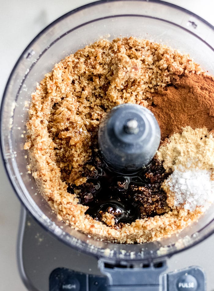 Spices, molasses and salt added to a dough mixture in a food processor.