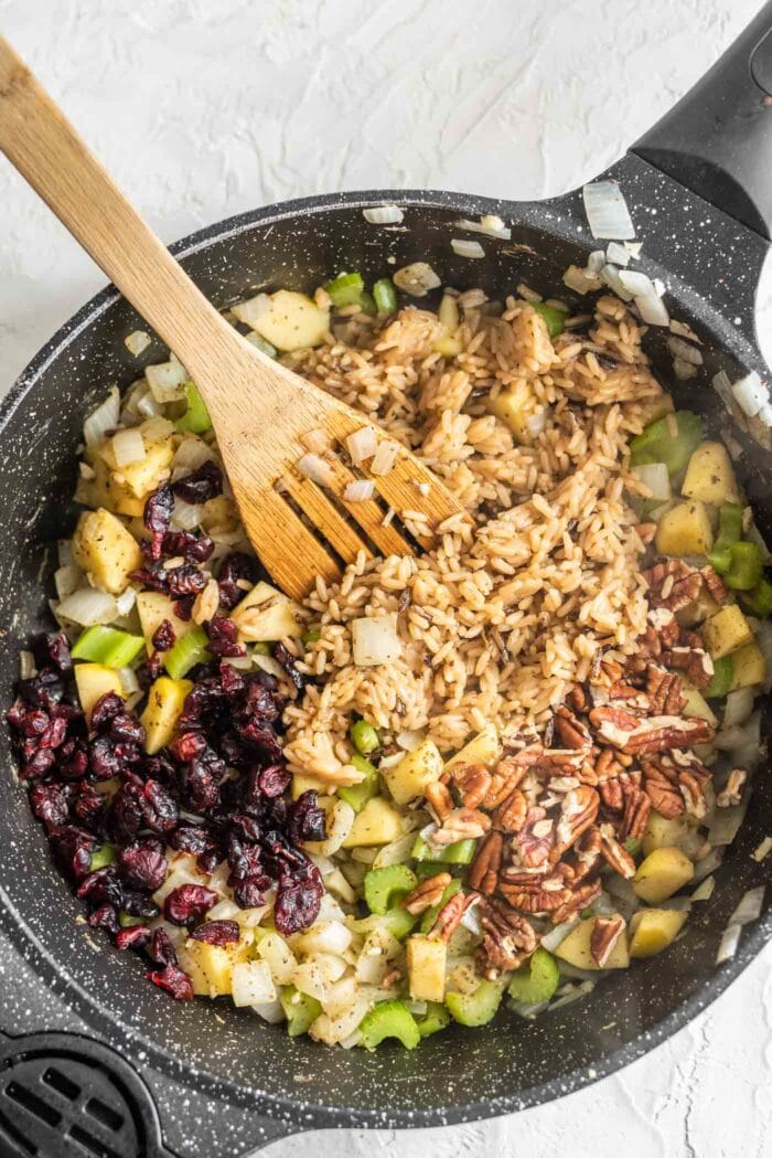 Rice, pecans, cranberries, apple and celery in a skillet.