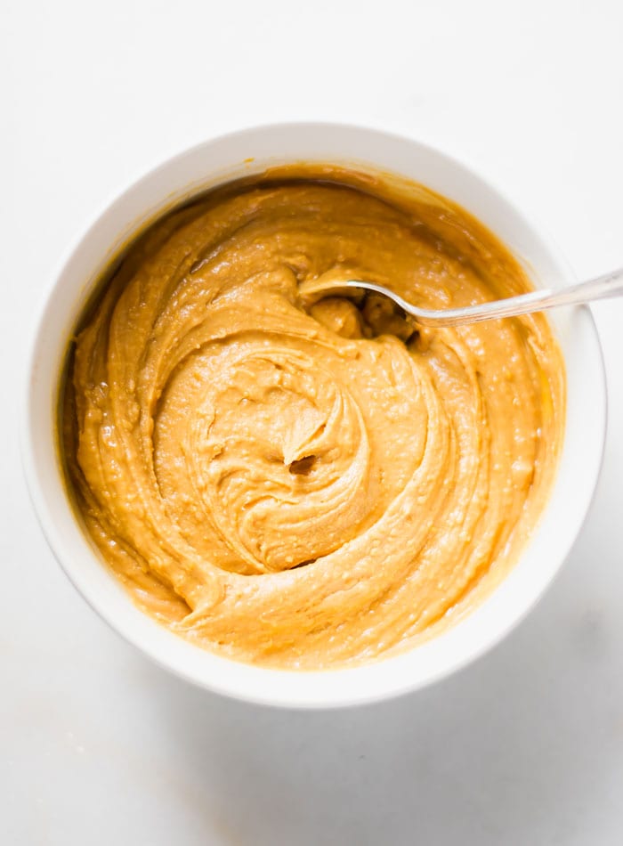 A creamy peanut butter mixture in a bowl with a spoon.