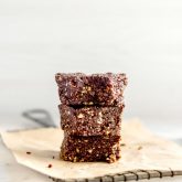 A stack of 3 no-bake coffee brownies on a square of parchment paper on a baking rack.