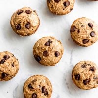 Vegan chocolate chip banana muffins on a marble surface.