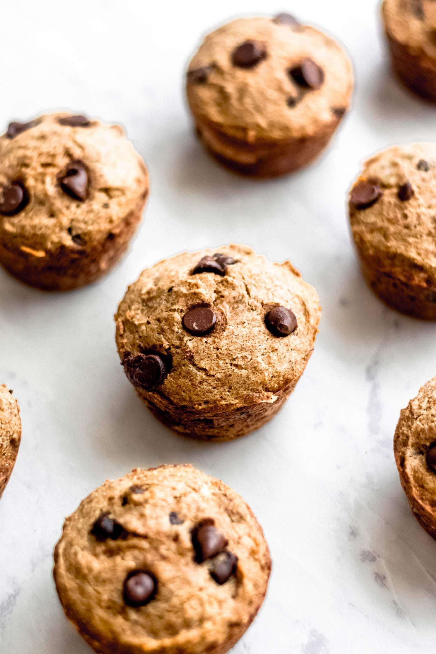 Vegan chocolate chip banana muffins on a marble surface.