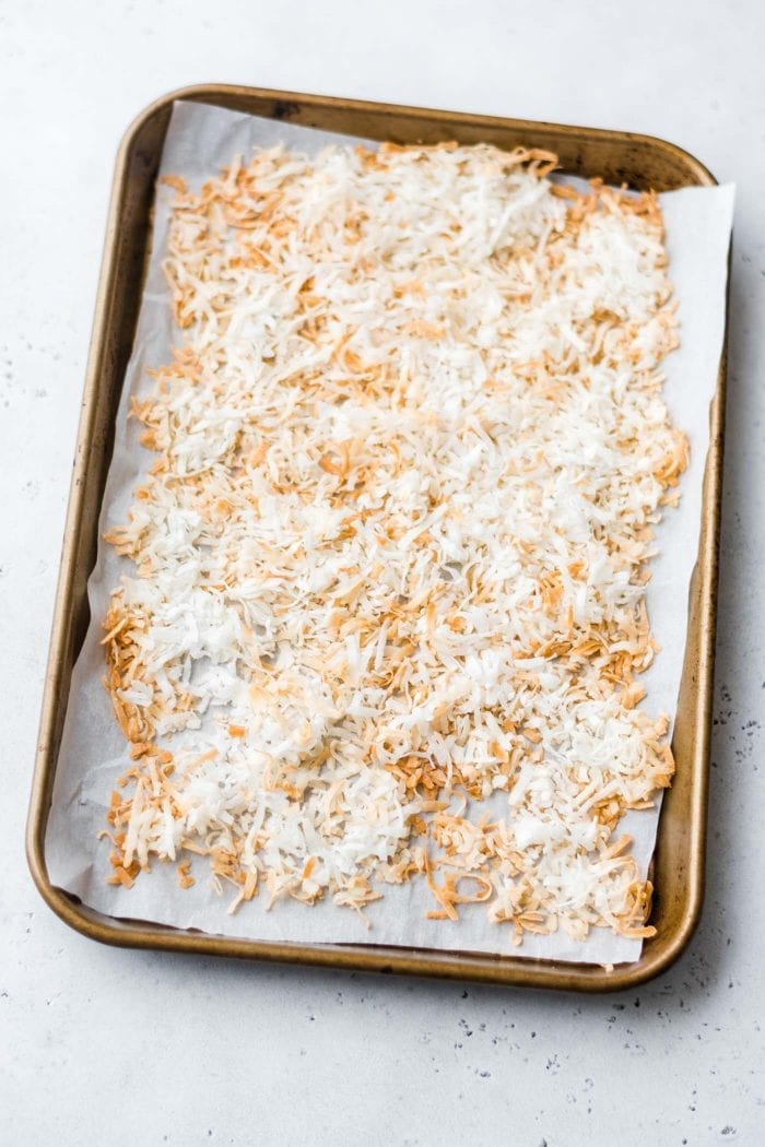 Toasted shredded coconut on a baking tray.
