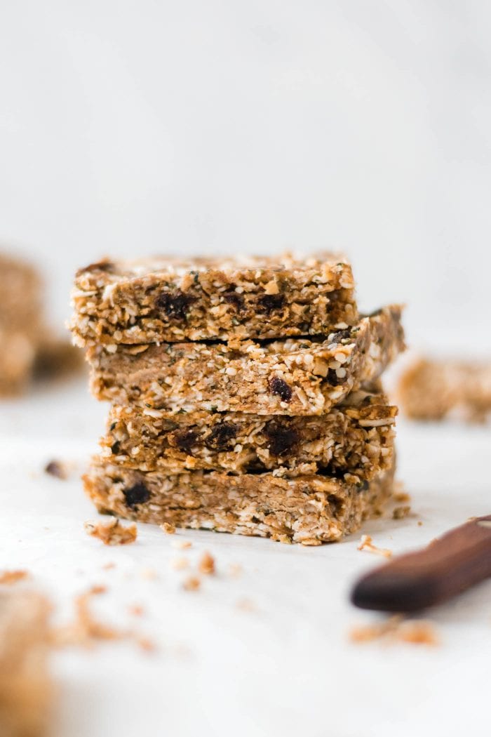 Stack of 4 paleo energy bars with hemp seeds, coconut and raisins.