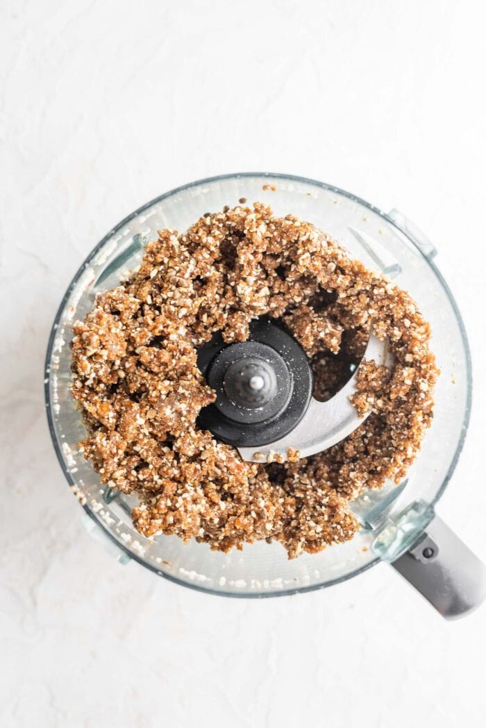Thick, sticky paleo energy bar dough with coconut, hemp seeds and cashews blended up in a food processor.