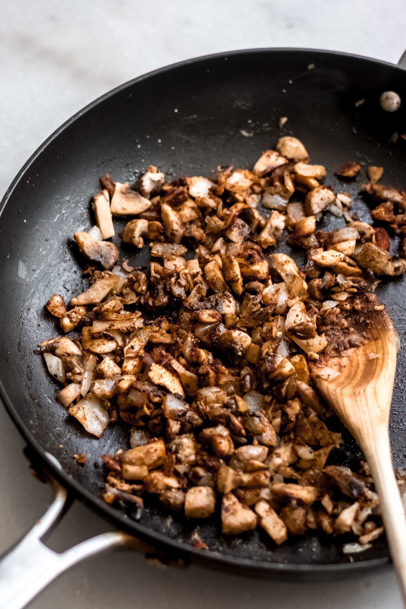 Sautéed mushrooms and onions in a skillet.