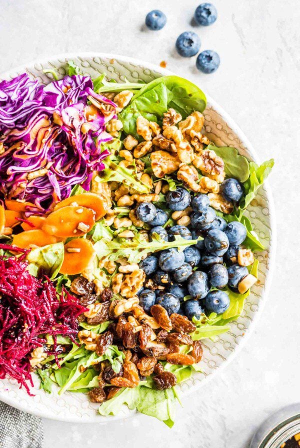 Beet walnut salad on a bed of spinach and arugula.