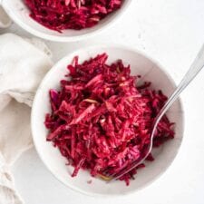 Overhead shot of two bowls of beet, apple and cabbage slaw in bowls.