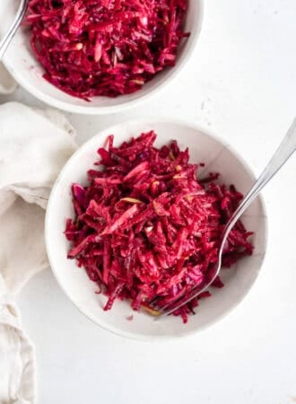 Overhead shot of two bowls of beet, apple and cabbage slaw in bowls.