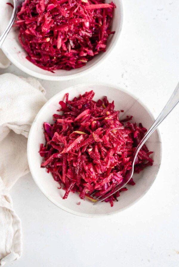 Overhead shot of two bowls of beet, apple and cabbage slaw in bowls.