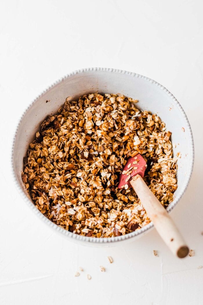 Raw pumpkin spice latte granola in a mixing bowl with a spoon.