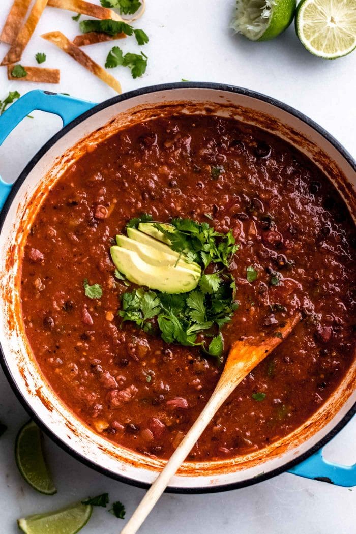 The best vegan tortilla soup in a soup pot topped with cilantro and avocado.