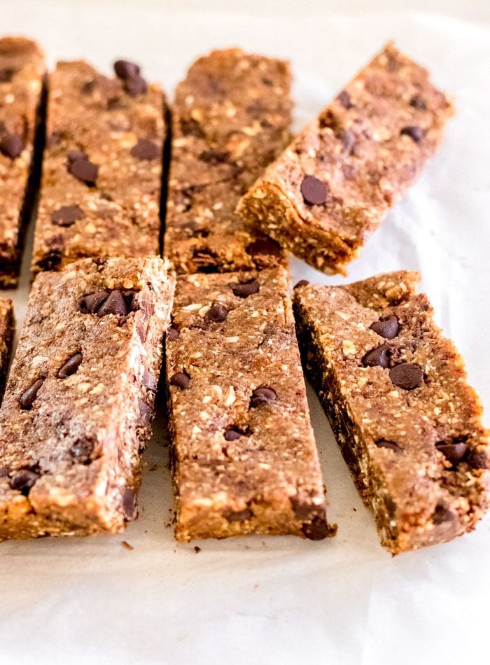 A number of chocolate chip granola bars on a piece of parchment paper.
