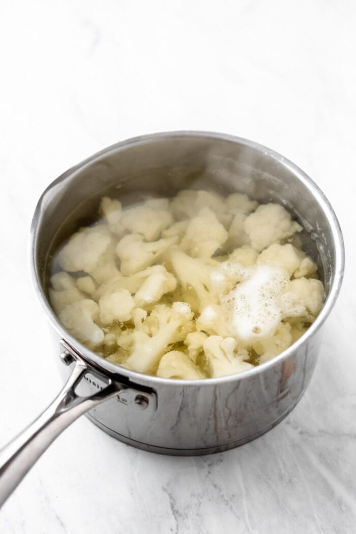 Cooked cauliflower florets in a pot of boiling water.