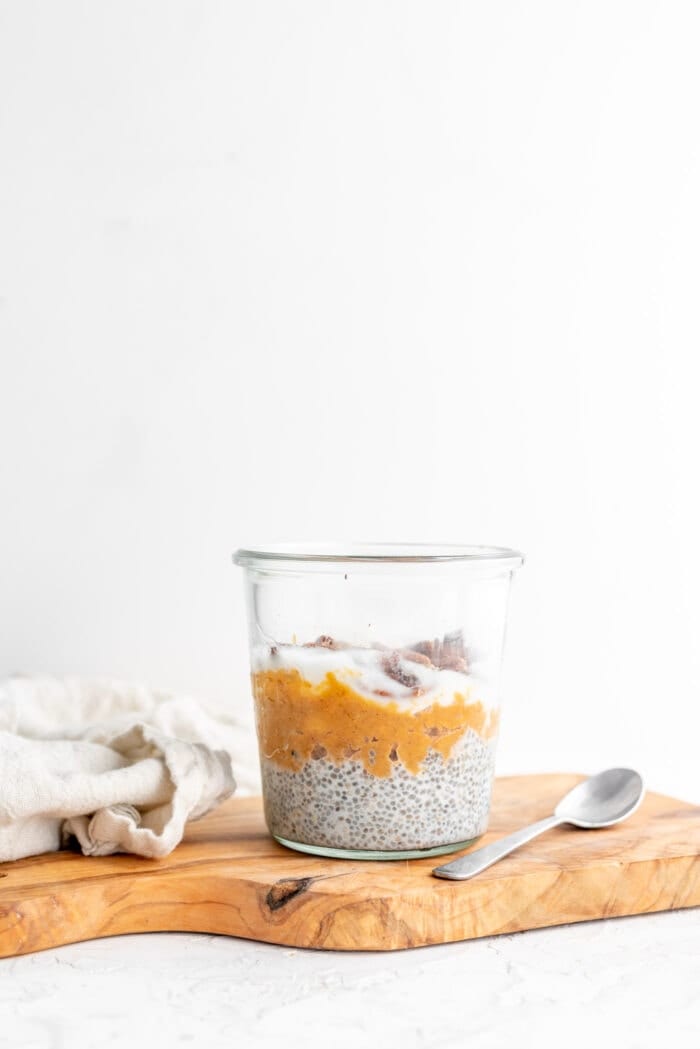 Jar layered with vanilla chia pudding and mashed sweet potato against a white background.
