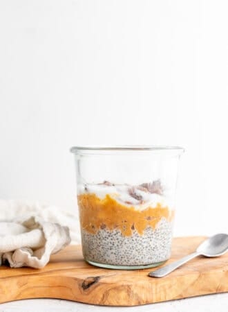 Jar layered with vanilla chia pudding and mashed sweet potato against a white background.