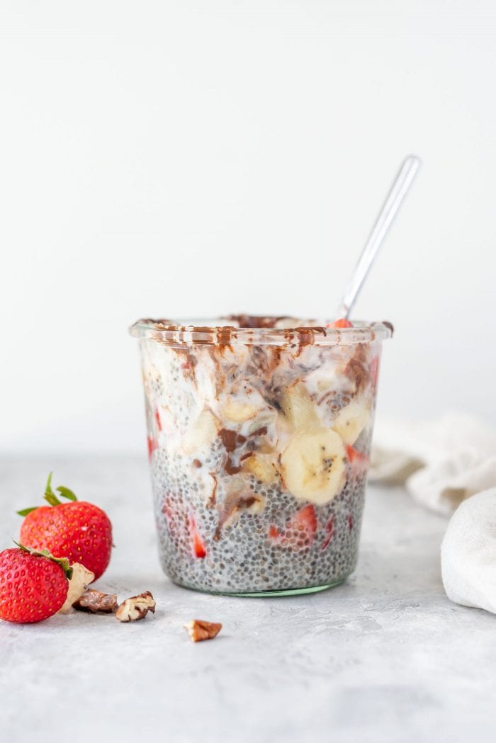Chia seed pudding with banana and strawberries in a glass jar.