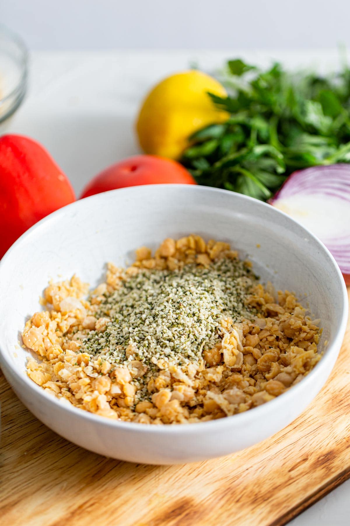 Vibrant Chickpea Tabouleh 4 Mashed chickpeas mixed with a generous amount of hemp seeds in a clean white bowl, ready for the addition of fresh vegetables and dressing.