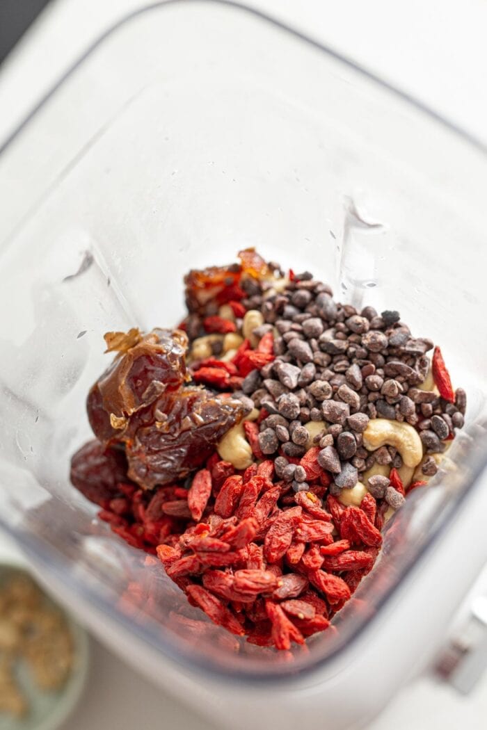 Goji berries, dates, cashews and cacao nibs in a blender.