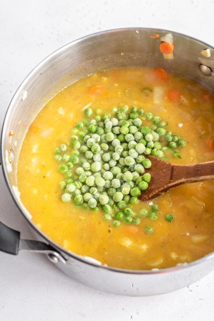 A pot of cauliflower soup with peas in it.
