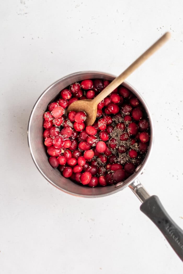 Whole cranberries in a small saucepan with chia seeds.
