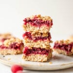 A stack of 3 cranberry crumble bars on a small grey plate.