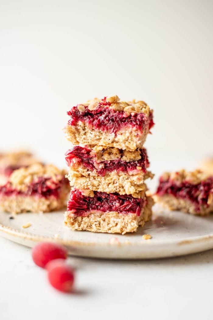A stack of 3 cranberry crumble bars on a small grey plate.