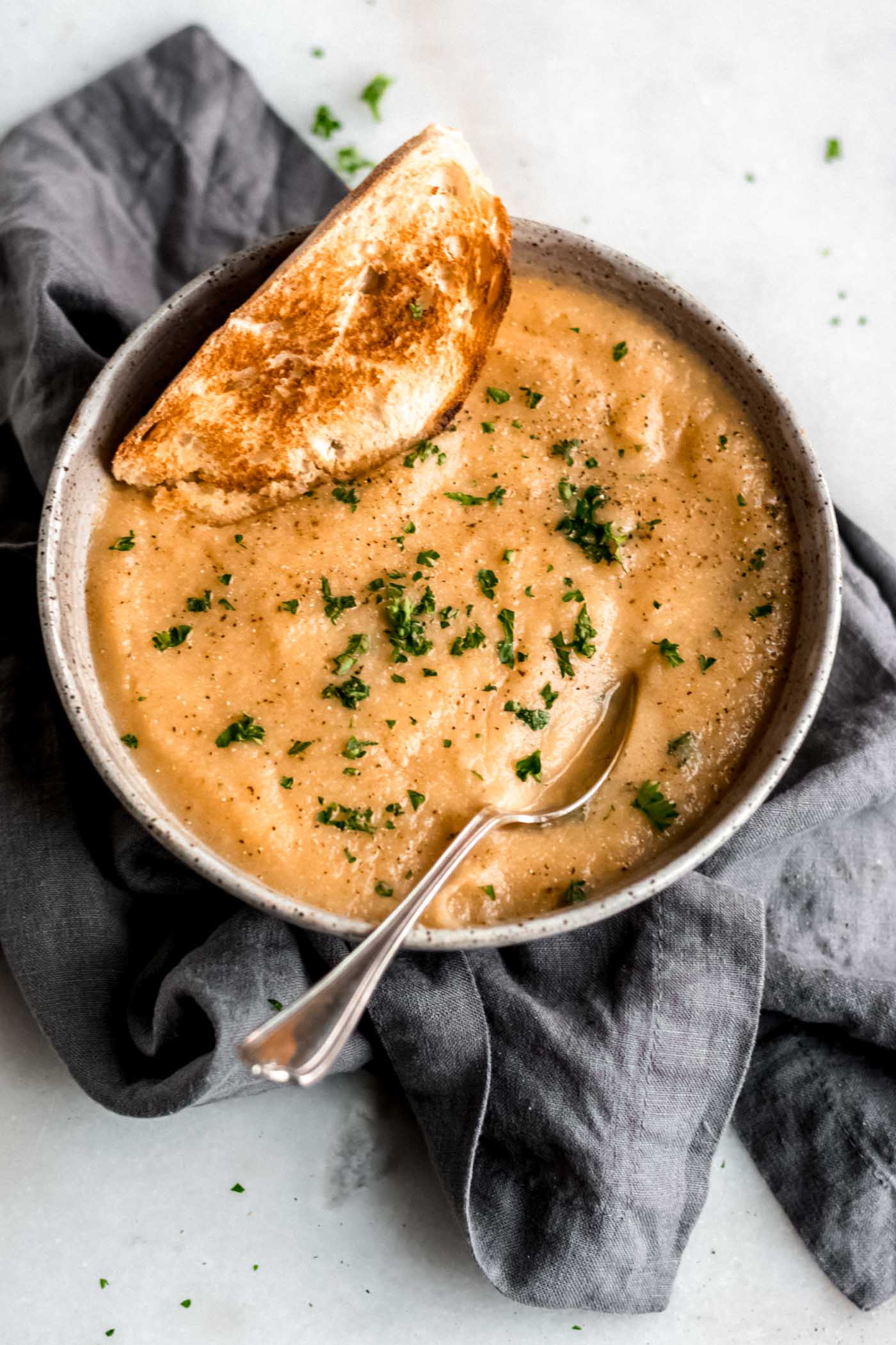 Healthy vegan roasted garlic cauliflower soup with fresh toasted bread.