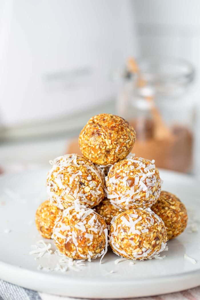 A stack of carrot cake energy balls on a plate.