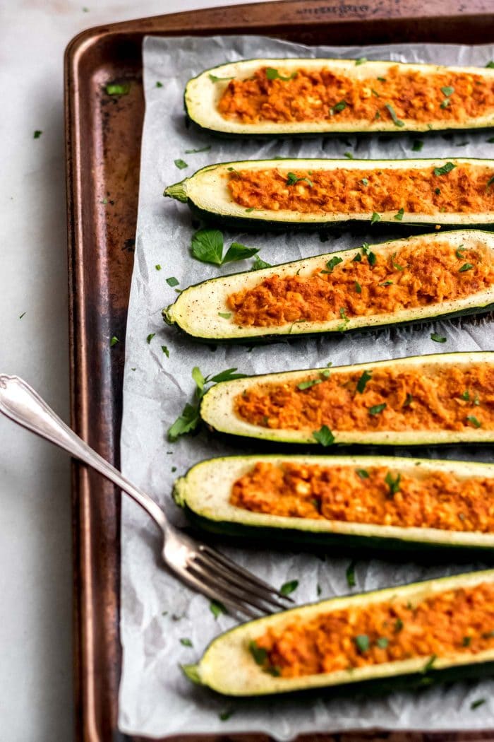 Easy Vegan Chickpea Stuffed Zucchini Boats on a baking tray.