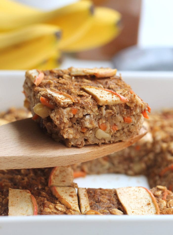 A slice of carrot cake baked oatmeal on a wooden spatula.