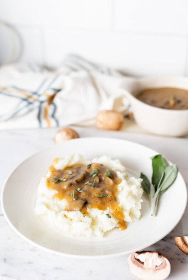 A plate of mashed potatoes topped with vegan mushroom gravy.