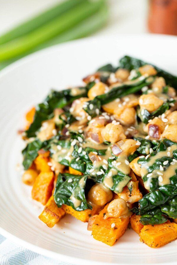 A plate of vegan kale chickpea stir fry with miso peanut sauce.