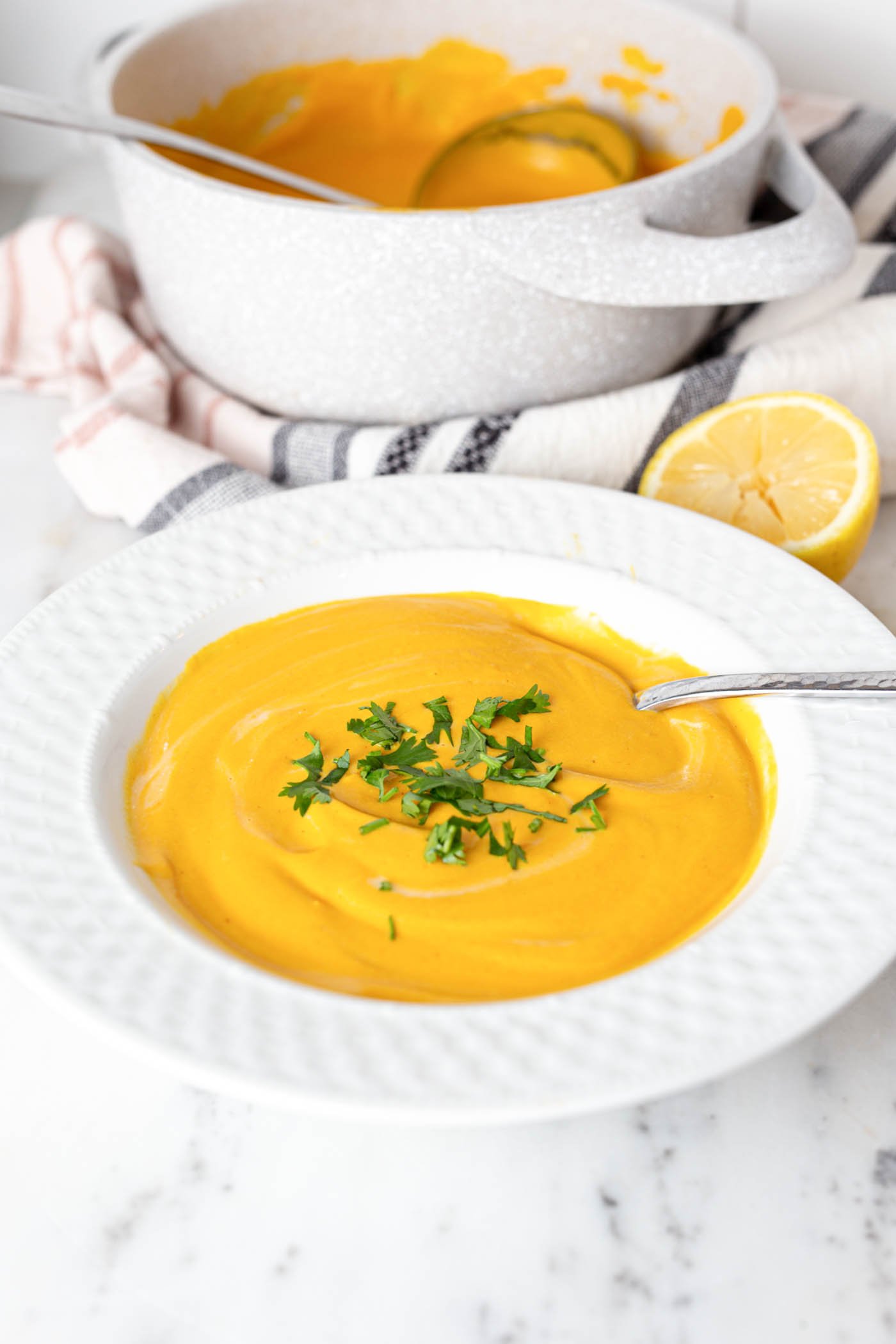 Bowl of creamy soup topped with parsley.