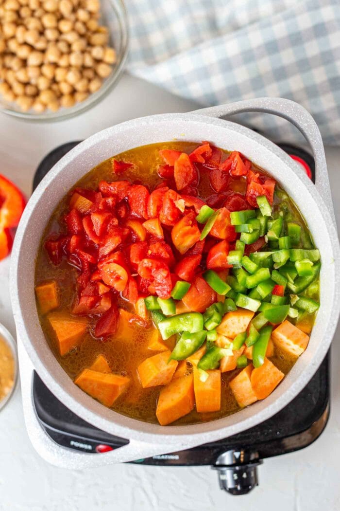 A large pot of sweet potato, tomato and bell peppers.