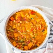 A large pot of sweet potato stew sitting on a dish towel.