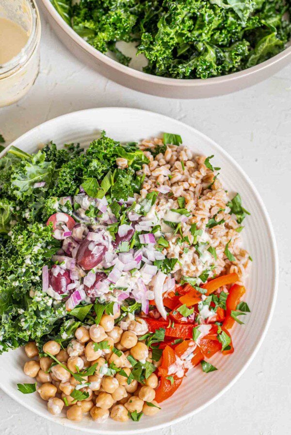 A farro salad with chickpeas, kale, roasted red peppers, olives and red onion.