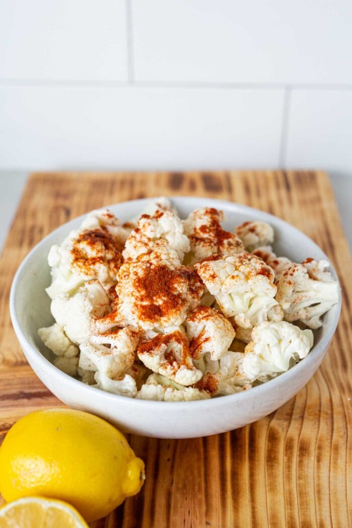 Chopped cauliflower in a bowl with spices.