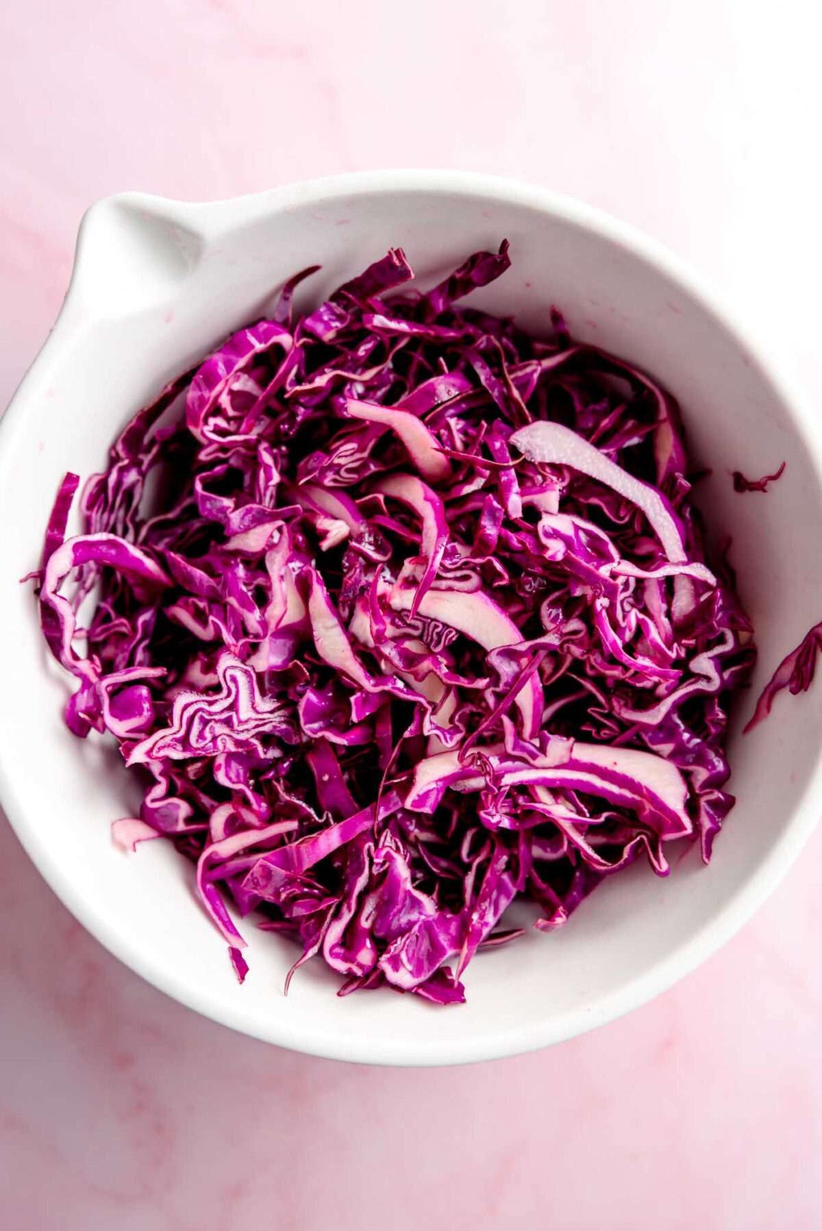 Thinly sliced red cabbage in a large bowl.