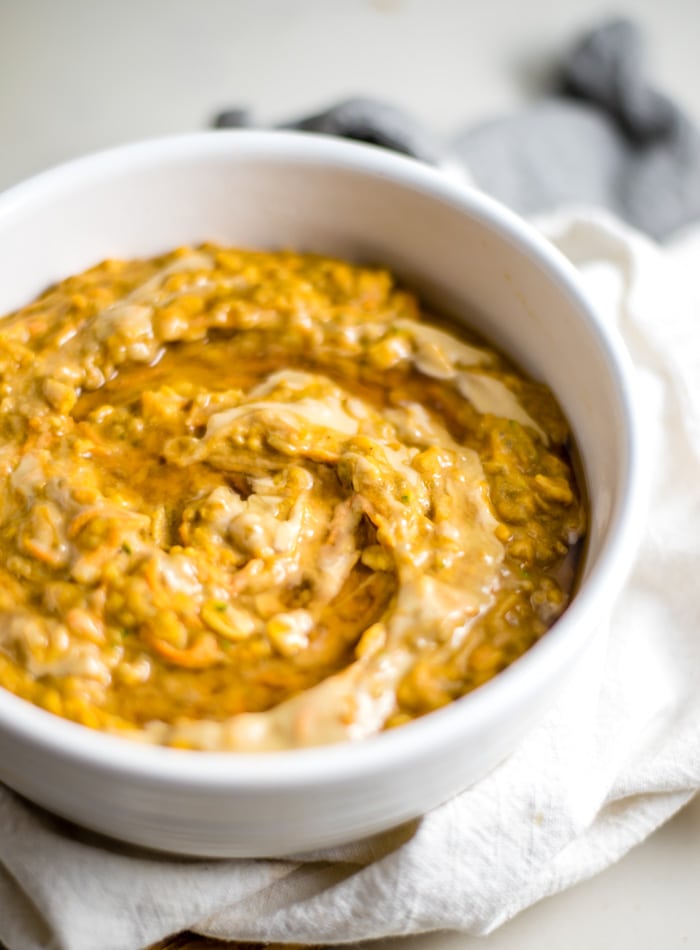 A bowl of creamy oatmeal made with carrot, pumpkin and zucchini.