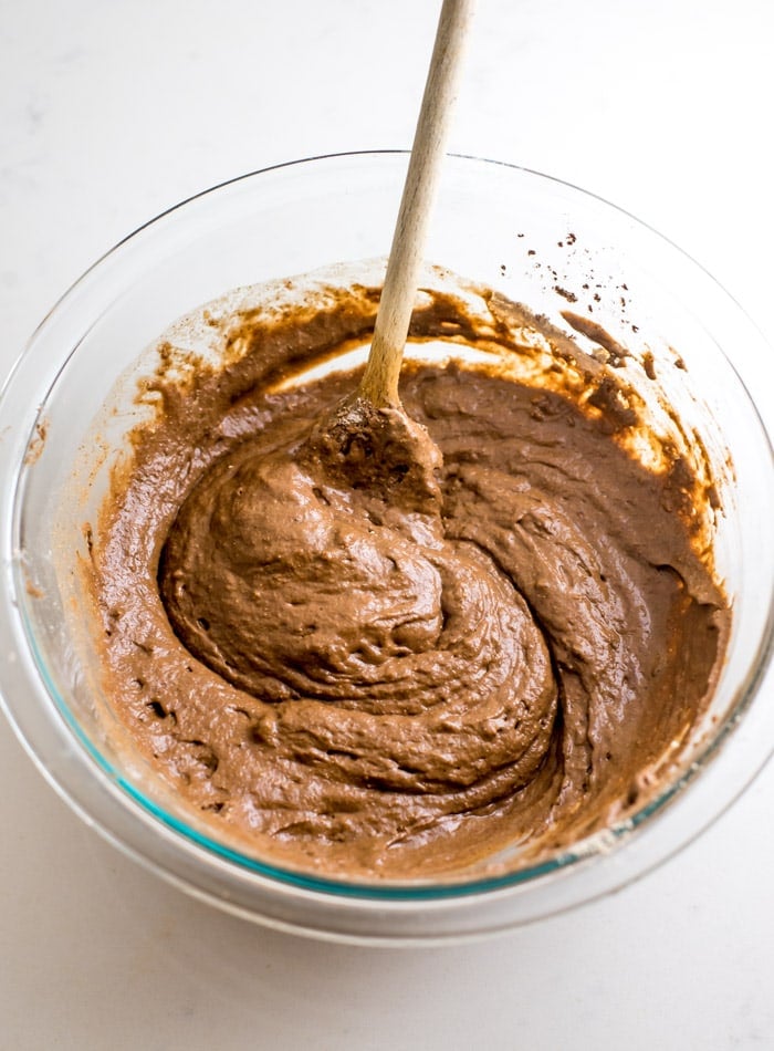 Raw chocolate pancake batter in a glass mixing bowl.
