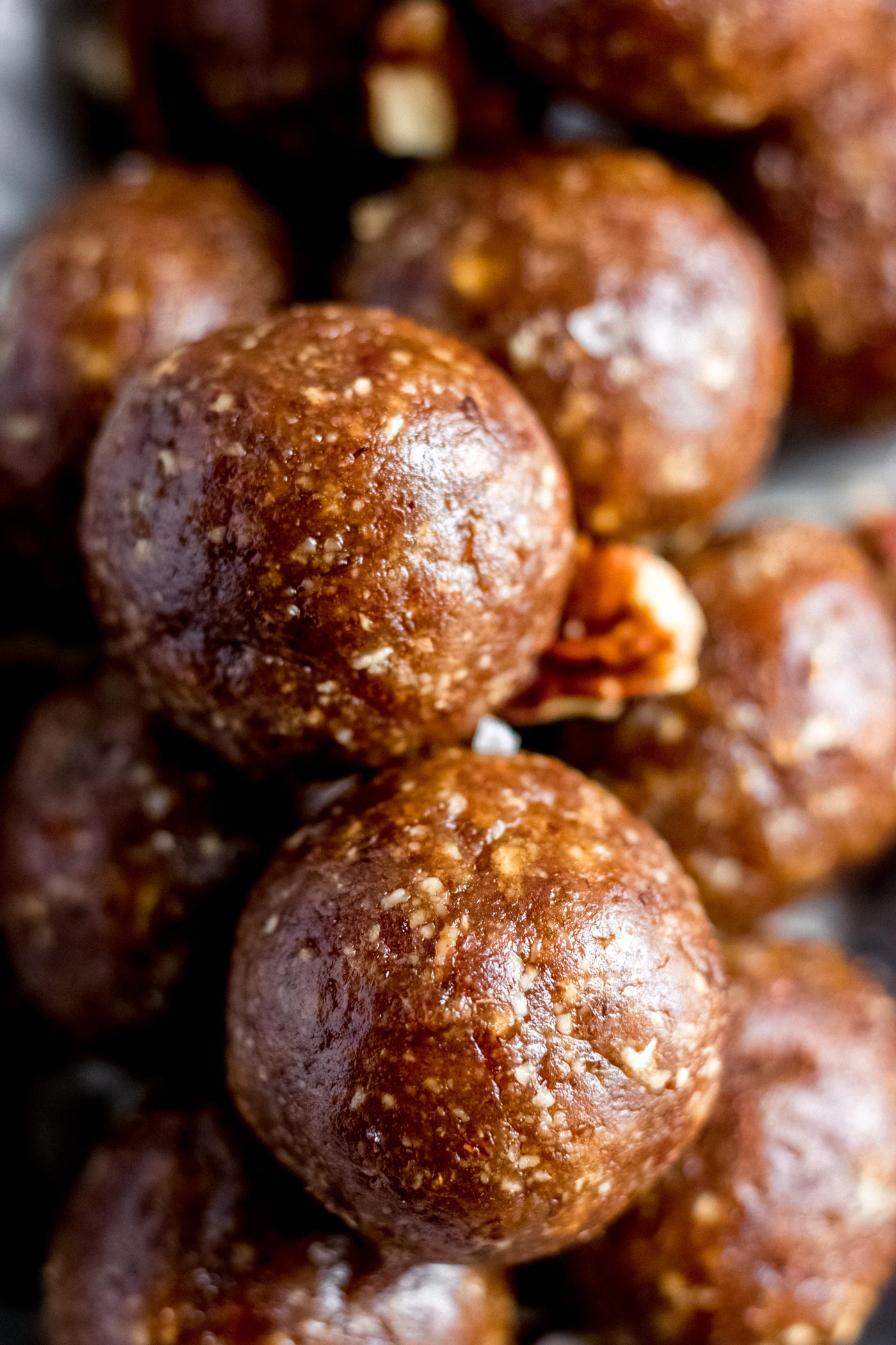 A plate full of no-bake pecan pie energy balls made from dates.