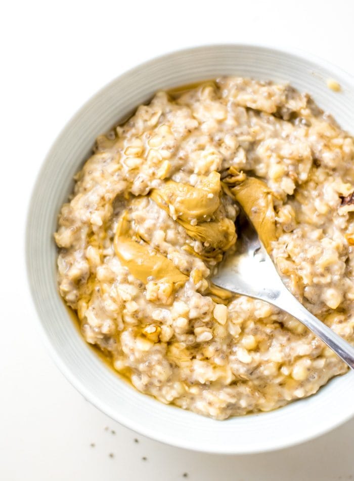 Bowl of banana oatmeal topped with peanut butter.